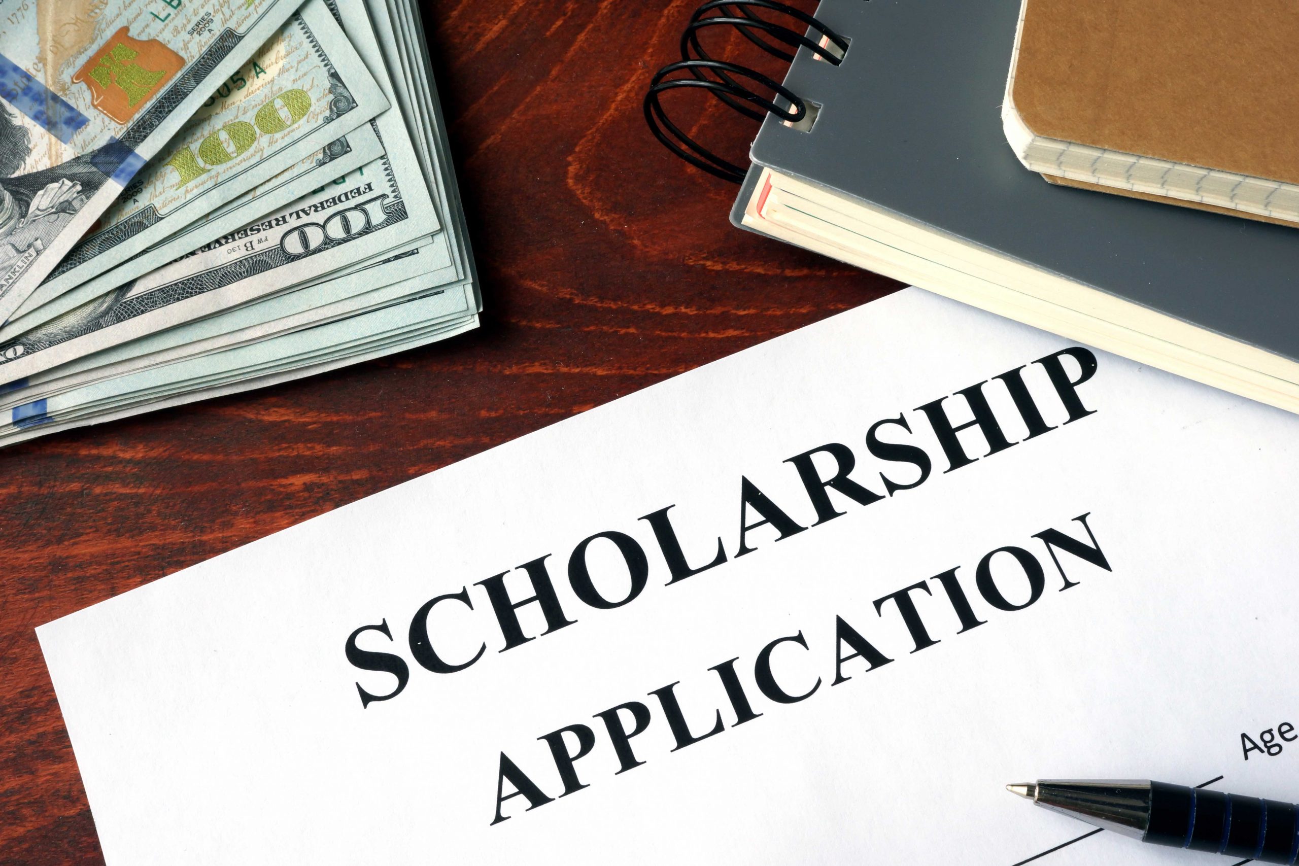 Scholarship Application on a table and dollars.