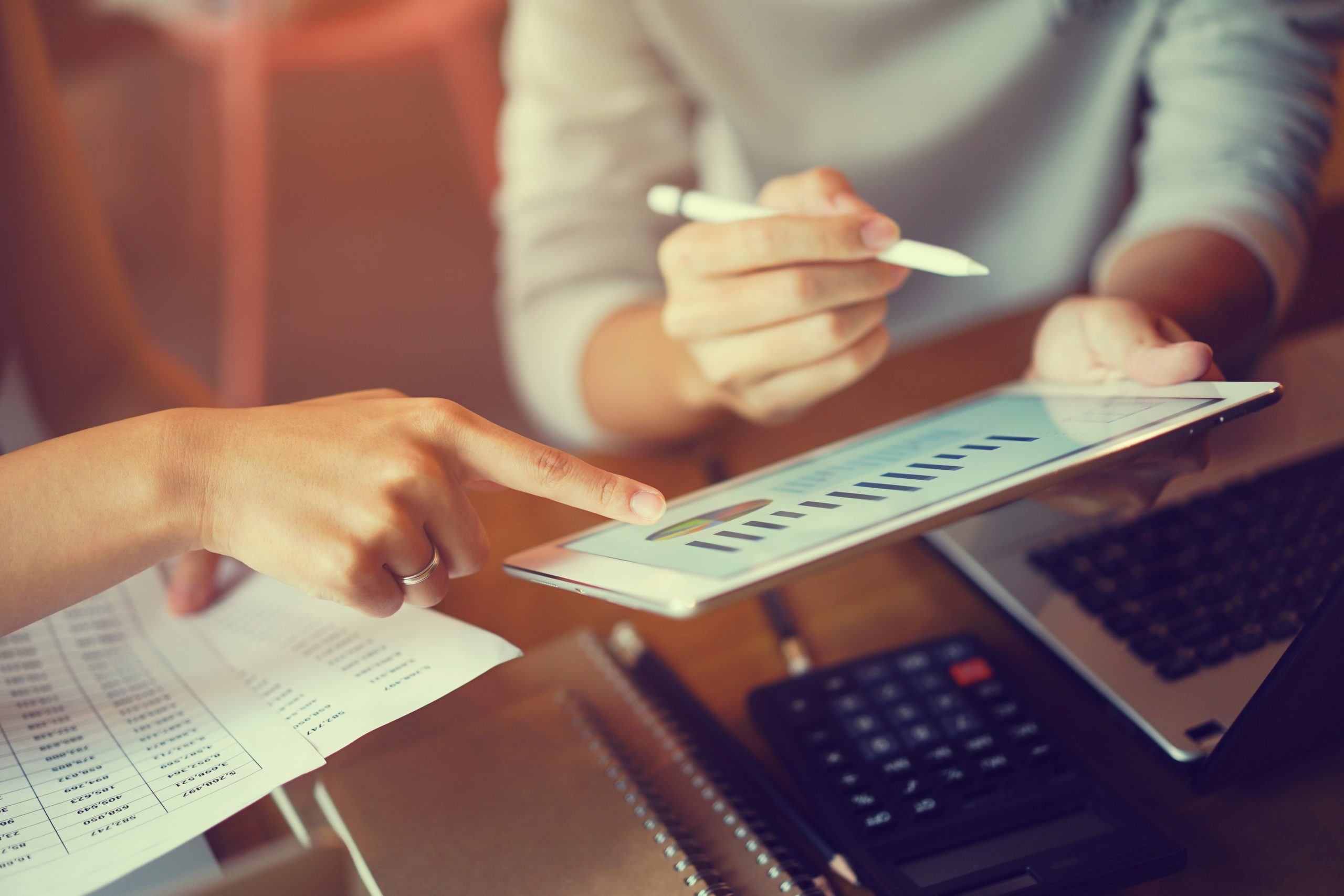 People work together while looking at a chart on a tablet.