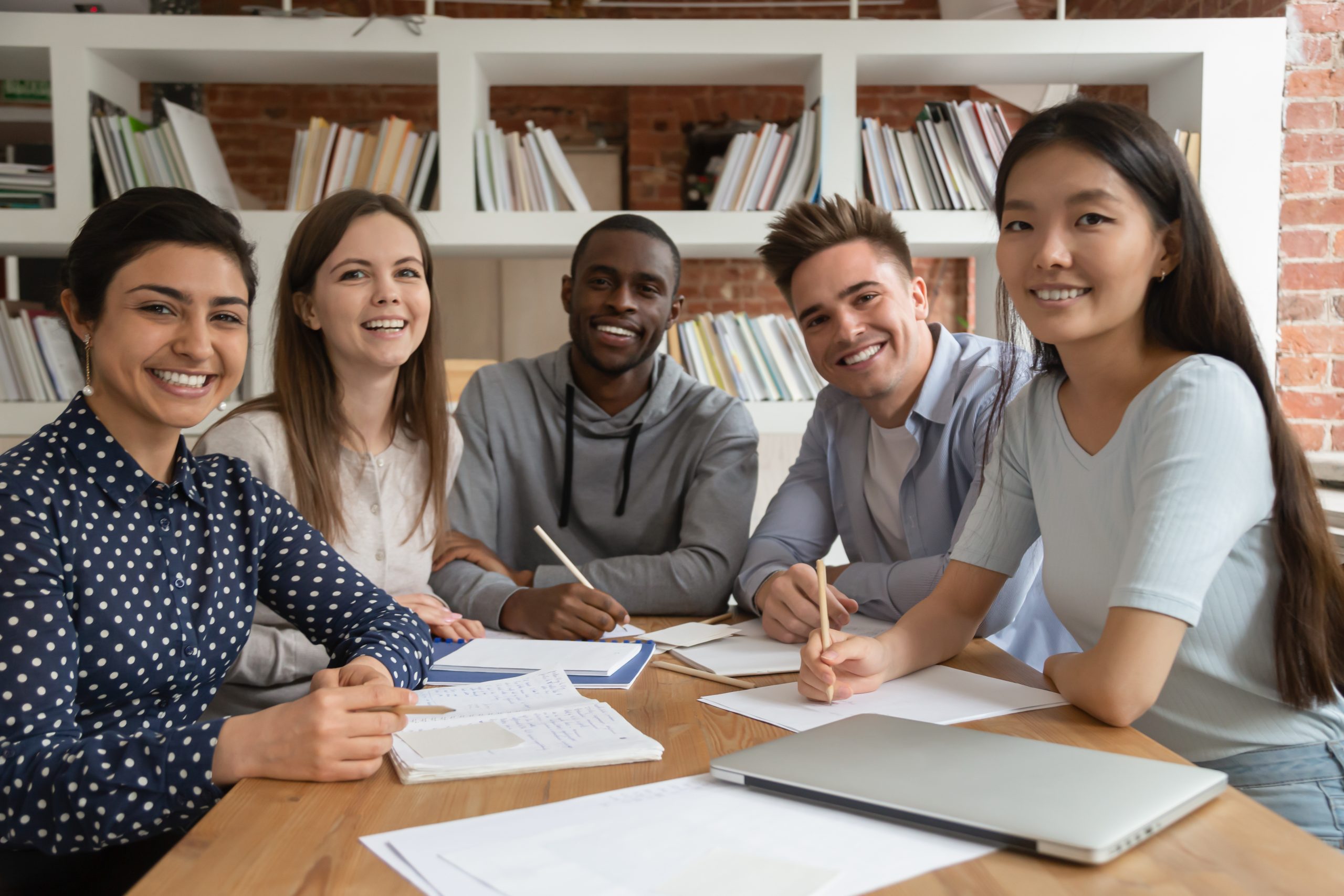 Group of people works together while sitting at a table.