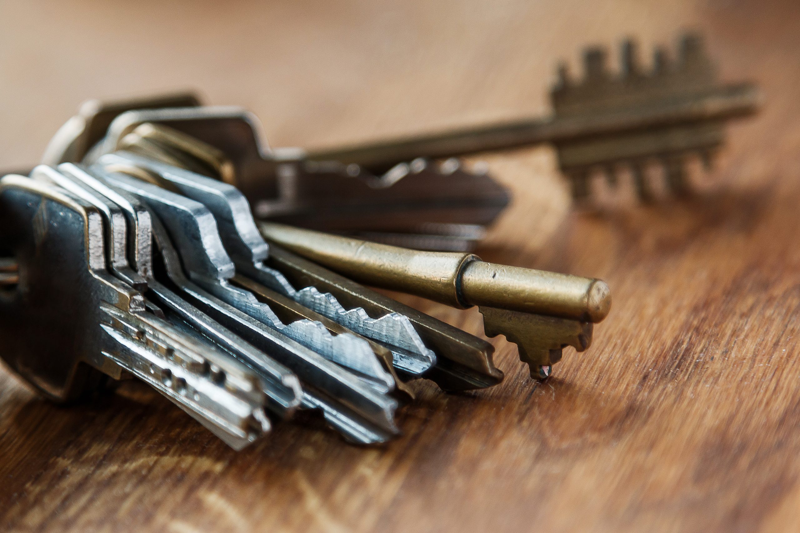 A keyring with a wide variety of keys sits on a table.