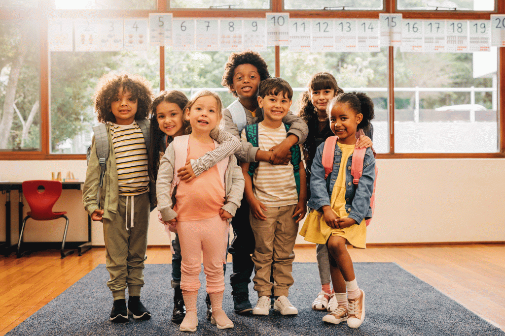 Group of elementary school students standing together in a classroom.