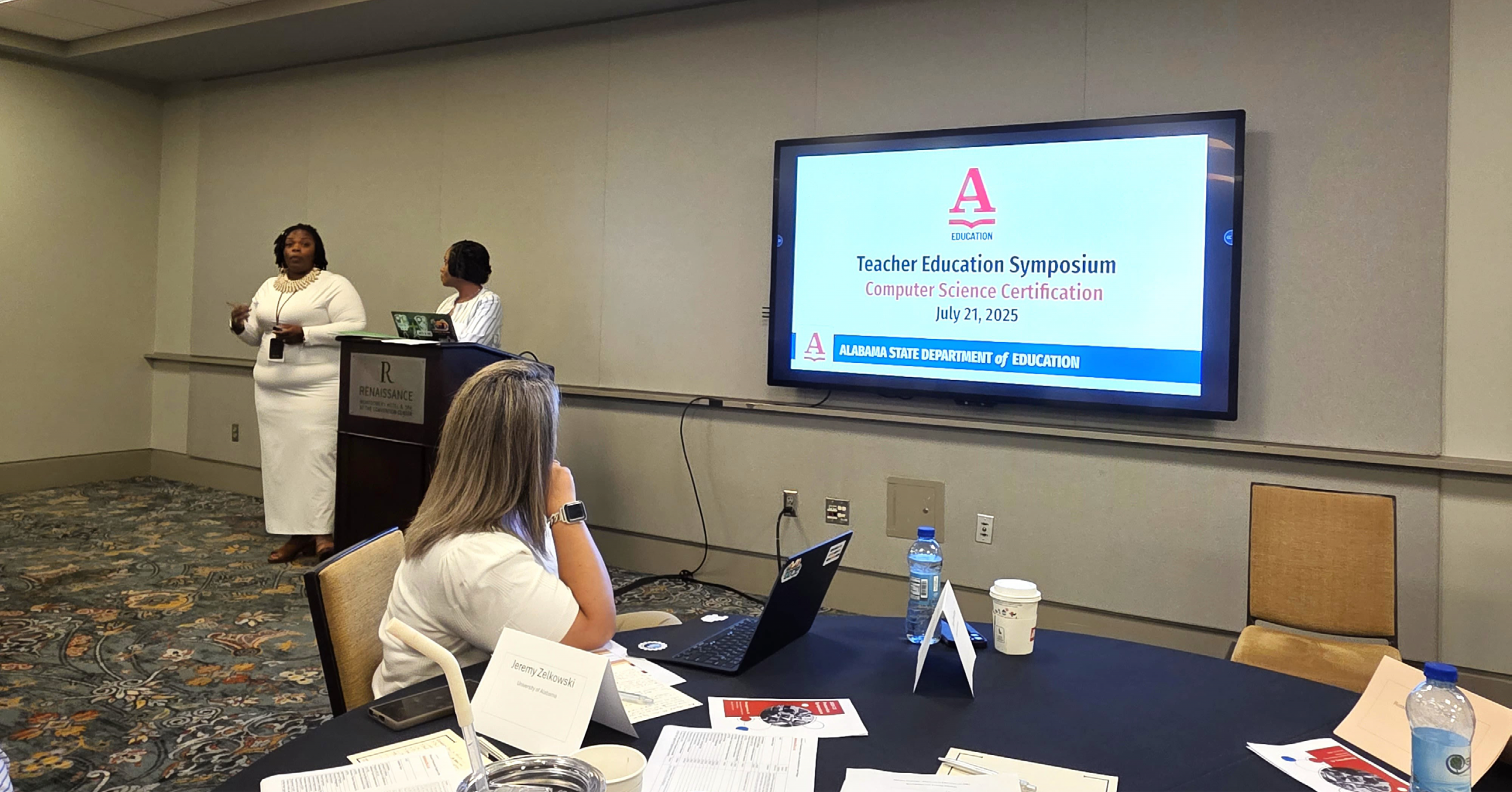 Two speakers talk with attendees of the Teacher Education Symposium on Computer Science Certification on July 21, 2025. This symposium was presented by the Alabama State Department of Education.
