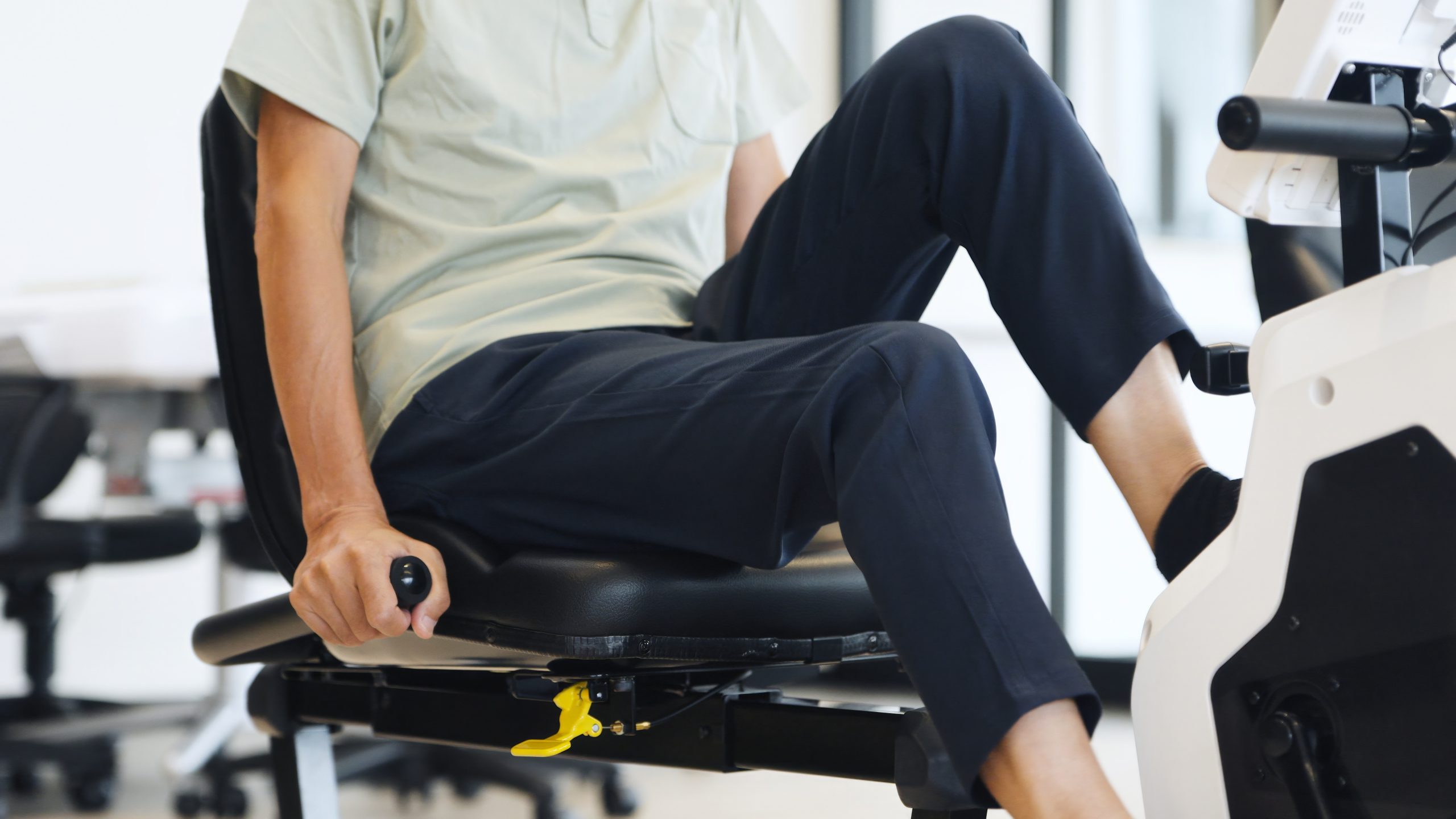 Elderly man works on exercise bike during sensorimotor recovery.