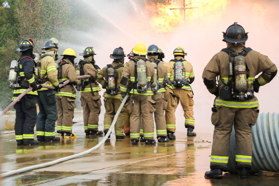 A group of firefighters work together to put out a large fire.